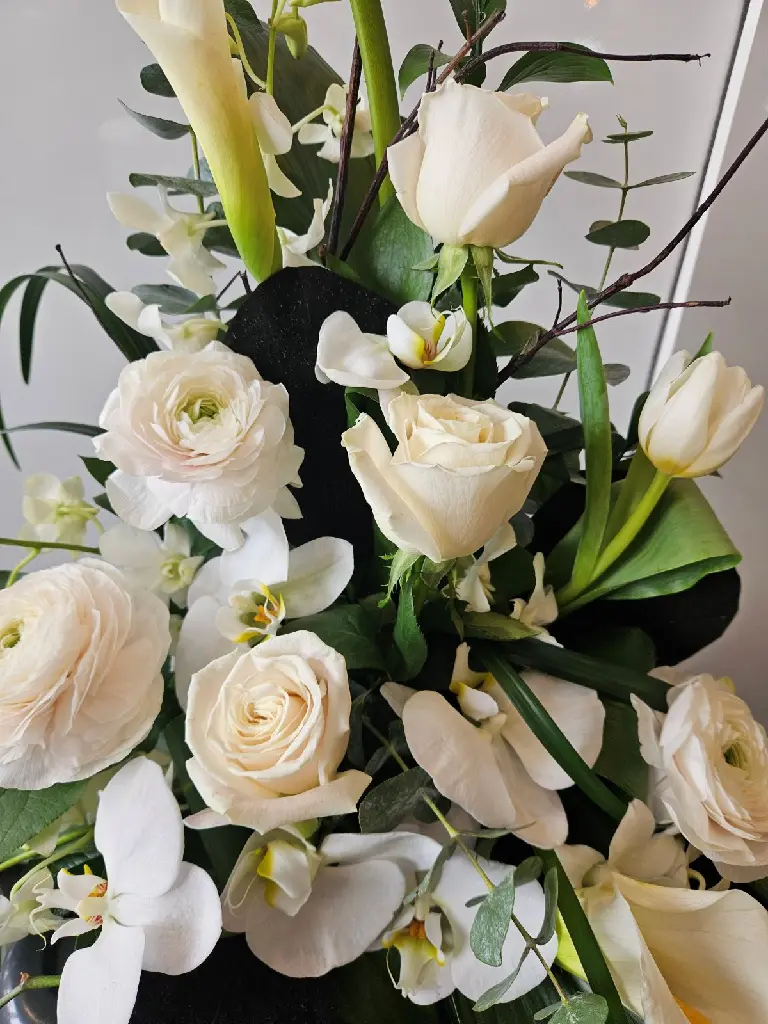 Accompagnement d’urne Paix infinie avec orchidées Phalaenopsis blanches, callas, roses, renoncules et tulipes à Montréal.1.webp