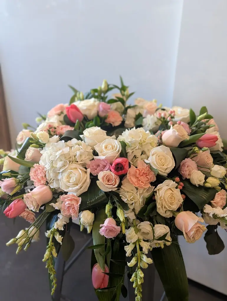 Tendre souvenir – accompagnement d’urne rose poudré, blanc et crème avec roses, hydrangées, tulipes et fleurs délicates à Montréal.1.webp