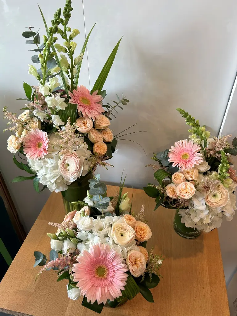 Jardin de tendresse – ensemble de trois arrangements floraux en vase rose, pêche et blanc pour accompagner une urne à Montréal.1.webp