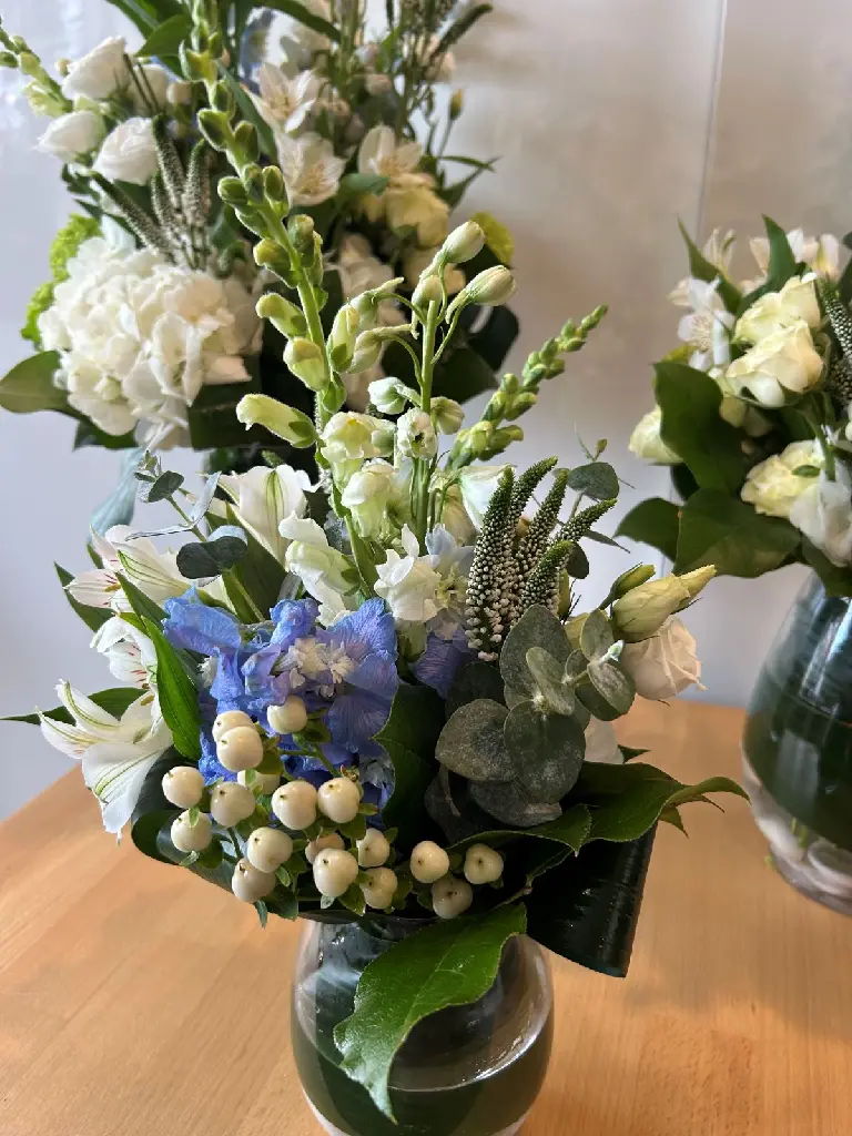 Souvenirs paisibles – trio d’arrangements floraux en vase blanc, vert et bleu pour accompagner une urne à Montréal.1.webp