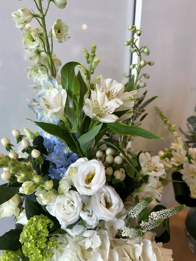 Souvenirs paisibles – trio d’arrangements floraux en vase blanc, vert et bleu pour accompagner une urne à Montréal.2.webp