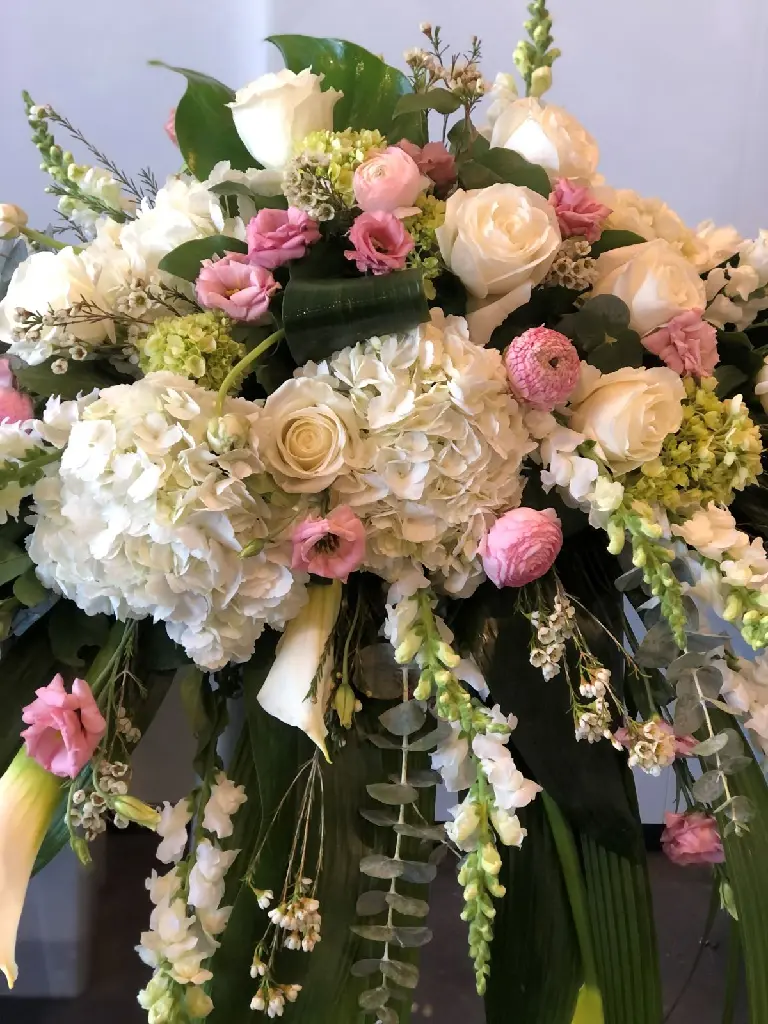 Tendre adieu – coussin de cercueil blanc et rose avec hydrangées, roses crème, callas, eucalyptus et fleurs délicates à Montréal.2.webp