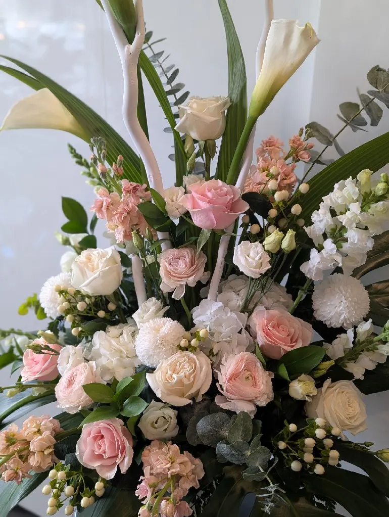 Composition funéraire Douce Sérénité avec callas, roses blanches et roses poudrées et fleurs blanches – La Maison d’Alcantara Montréal (1).webp