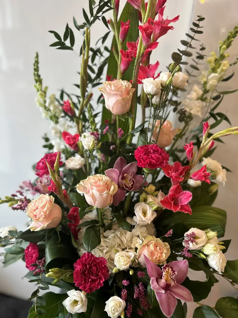 Composition funéraire À jamais dans nos cœurs avec roses roses, orchidées, œillets et fleurs blanches – La Maison d’Alcantara Montréal.1.webp