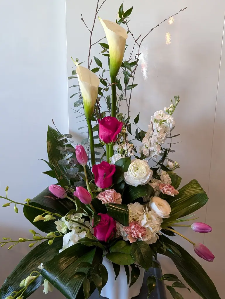 Composition funéraire Avec toute notre tendresse avec callas blancs, roses fuchsia, tulipes roses et fleurs blanches – La Maison d’Alcantara Montréal.1.webp