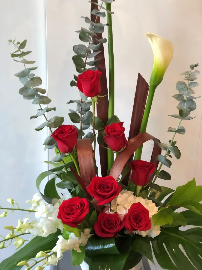 Composition funéraire Amour éternel avec roses rouges, callas ivoire, fleurs blanches et feuillage tropical – La Maison d’Alcantara Montréal.1.webp