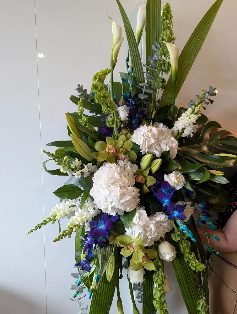 Gerbe murale funéraire Souvenir d’azur avec orchidées bleues et vertes, hortensias blancs et callas – La Maison d’Alcantara Montréal.webp