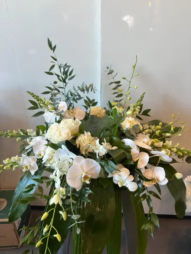 Accompagnement d’urne roses blanches et orchidées